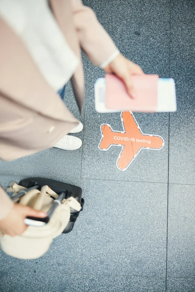 A traveller with a passport and boarding pass in an airport
