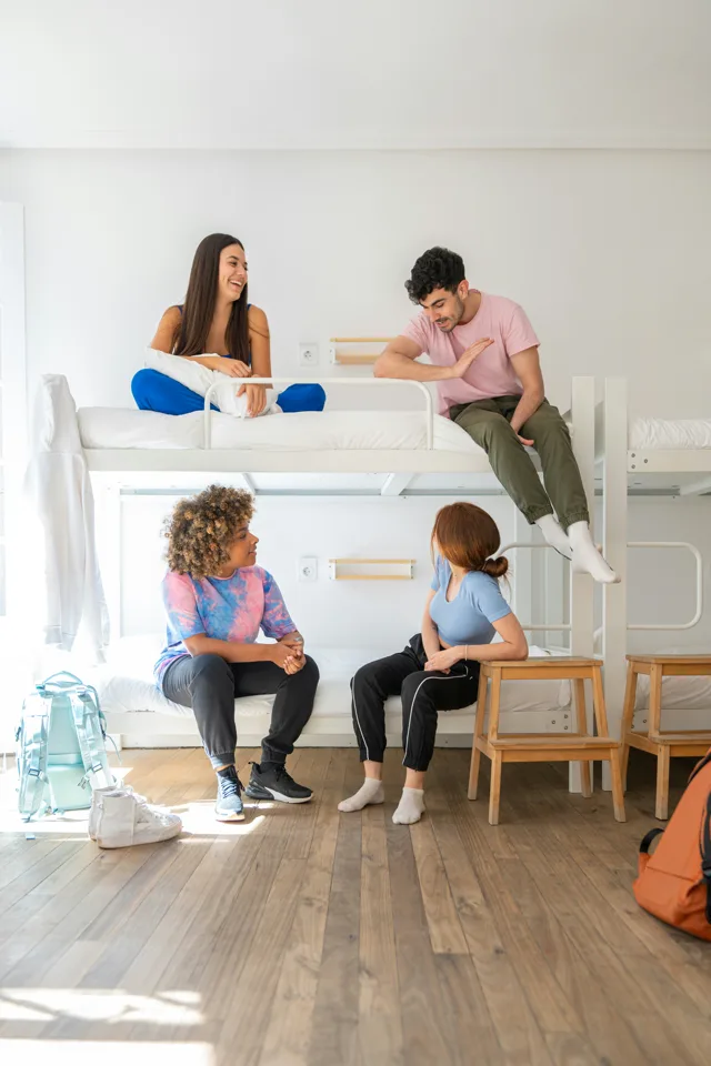 A hostel dormitory with bunk beds and travellers