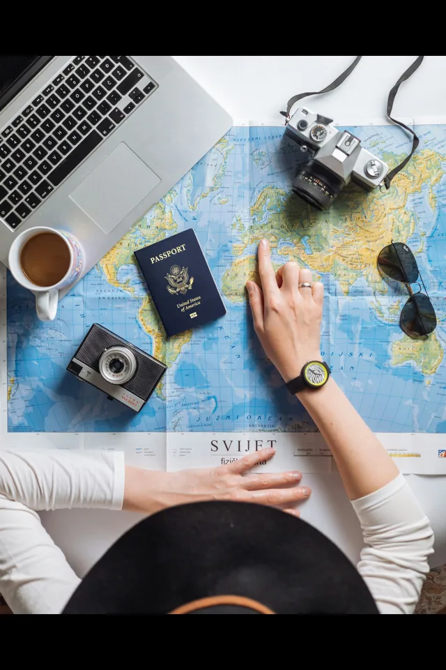 A flat-lay of a map, passport, camera and notebook for planning a China trip
