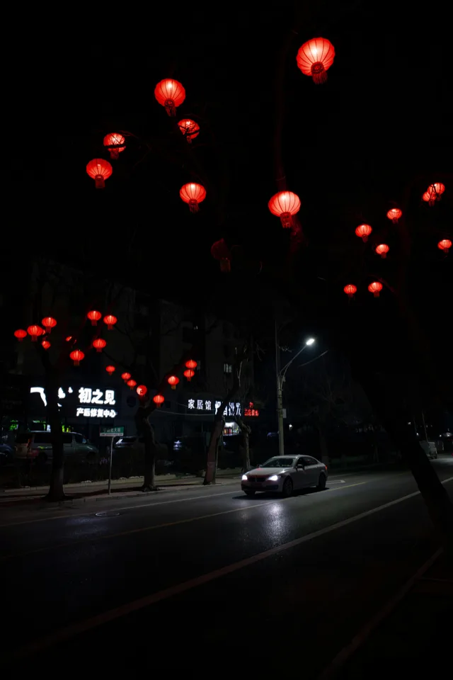 Red lanterns glowing over a Beijing street at night