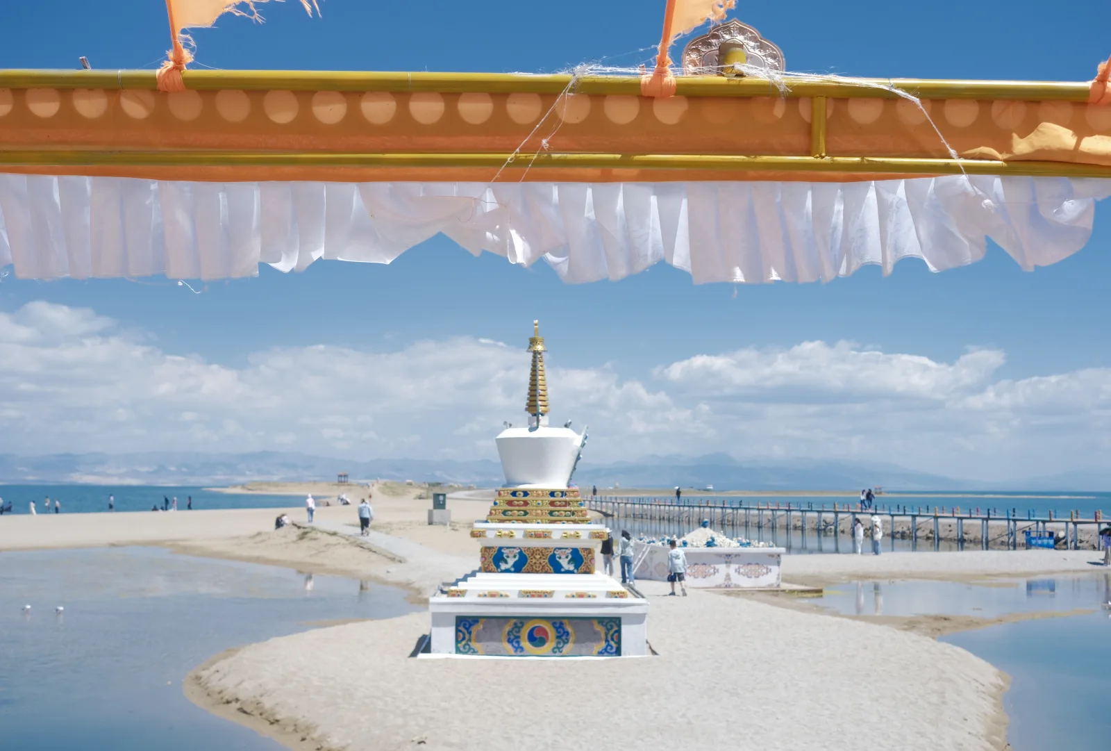 A white stupa on the lakeshore beneath the blue sky at Qinghai Lake